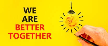 We are better together symbol. Concept words phrase We are better together on beautiful yellow paper. Businessman's hand. Beautiful yellow background Business We are better together concept Copy spaceの写真素材