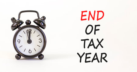 End of tax year symbol. Concept words phrase End of tax year on beautiful white paper. Black alarm...
