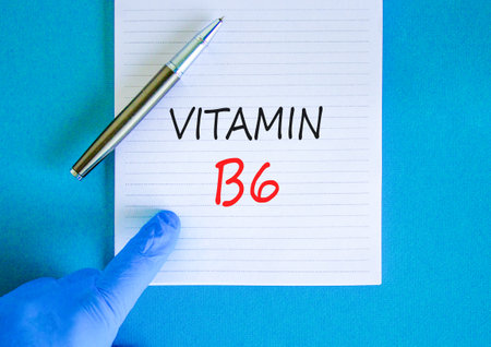 Vitamin B6 symbol. Concept words Vitamin B6 on beautiful white note. Doctor's hand in blue medical glove. Black pen. Beautiful blue background. Medical healthy lifestyle Vitamin B6 concept.の写真素材