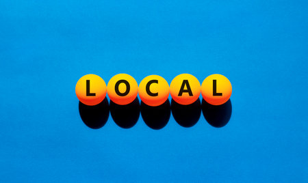 Local symbol. Concept word Local on beautiful yellow tennis ping pong balls. Beautiful wooden table...