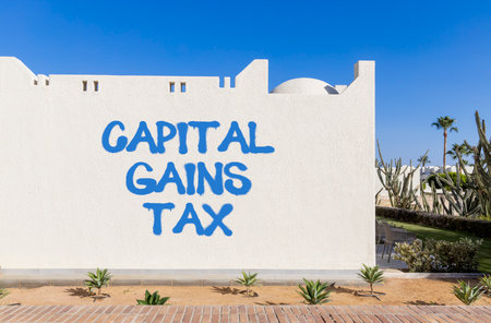 Capital gains tax symbol. Concept words Capital gains tax on beautiful white wall. Beautiful white wall blue sky background. Business and capital gains tax concept. Copy space.の写真素材