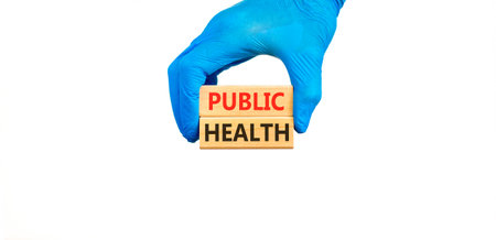Public health symbol. Concept words Public health on beautiful wooden blocks. Doctor's hand in blue medical glove. Beautiful white background. Medical healthy lifestyle public health concept.の写真素材