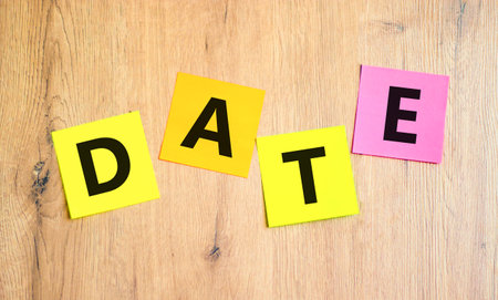 Date symbol. Concept word Date on beautiful colored paper. Beautiful wooden table wooden background. Business and date concept. Copy space.の写真素材