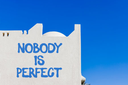 Nobody is perfect symbol. Concept words Nobody is perfect on beautiful white wall. Beautiful white wall blue sky background. Business motivational lifestyle and nobody is perfect concept. Copy space.の写真素材