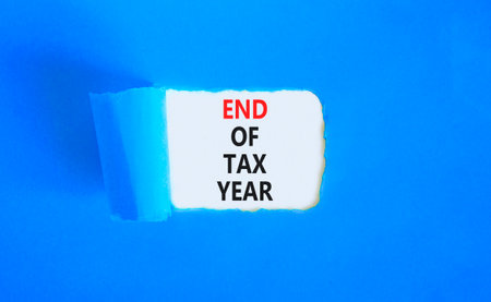 End of tax year symbol. Concept words phrase End of tax year on beautiful white paper. Beautiful blue paper background. Business End of tax year concept. Copy space.の写真素材