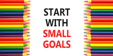 Start with small goals symbol. Concept words phrase Start with small goals on beautiful paper. Colored pencils. Beautiful white paper background. Business Start with small goals concept. Copy space.の写真素材