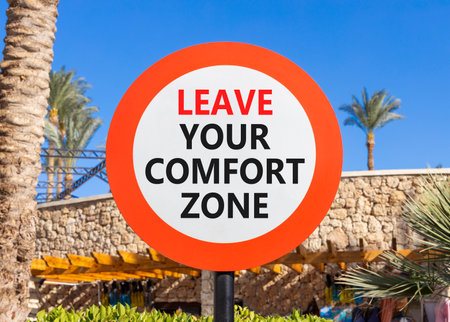 Leave your comfort zone symbol. Concept words Leave your comfort zone on beautiful road sign. Beautiful palm blue sky background. Business psychological Leave your comfort zone concept. Copy space.の写真素材