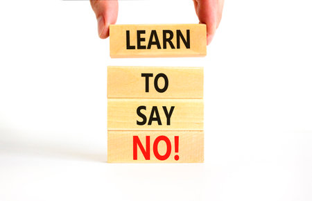 Learn to say no symbol. Concept words phrase Learn to say no on beautiful wooden blocks. Beautiful white paper background. Businessman's hand. Business psychological Learn to say no concept Copy spaceの写真素材