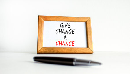 Give change a chance symbol. Concept words phrase Give change a chance on beautiful wooden picture frame. Black pen. Beautiful white background. Business Give change a chance concept. Copy space.の写真素材