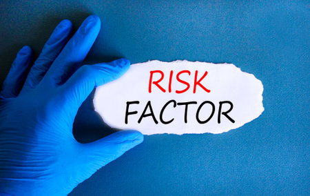 Risk factor symbol. Concept words Risk factor on beautiful white paper. Doctor's hand in blue medical glove. Beautiful blue background. Medical healthy lifestyle risk factor concept.の写真素材