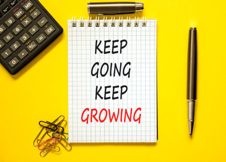 Keep going and growing symbol. Concept words phrase Keep going keep growing on beautiful white note. Calculator. Beautiful yellow background. Business Keep going and growing concept. Copy space.の写真素材
