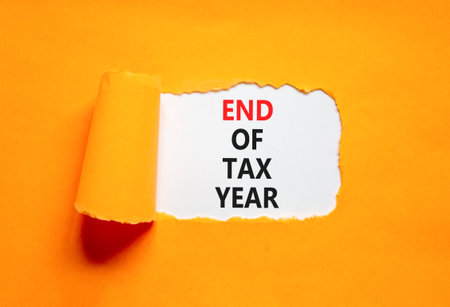 End of tax year symbol. Concept words phrase End of tax year on beautiful white paper. Beautiful orange paper background. Business End of tax year concept. Copy space.の写真素材