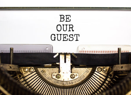 Be our guest symbol. Concept words Be our guest typed on beautiful old retro typewriter. Beautiful white paper background. Business and be our guest concept. Copy space.の写真素材