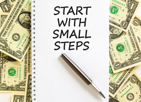 Start with small steps symbol. Concept words phrase Start with small steps on beautiful white note. Dollar bills. Beautiful dollar bills background. Business Start with small steps concept. Copy spaceの写真素材