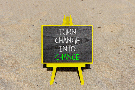 Turn change into chance symbol. Concept words phrase Turn change into chance on beautiful black blackboard. Beautiful sand beach background. Business Turn change into chance concept. Copy space.の写真素材