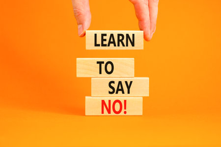 Learn to say no symbol. Concept words phrase Learn to say no on beautiful wooden blocks. Beautiful orange paper background. Businessman's hand Business psychological Learn to say no concept Copy spaceの写真素材