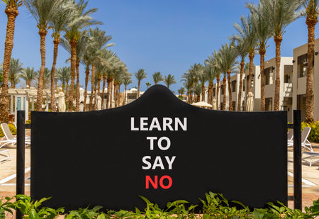 Learn to say no symbol. Concept words phrase Learn to say no on beautiful big black road sign. Beautiful palm tree blue sky background. Business psychological Learn to say no concept. Copy space.の写真素材