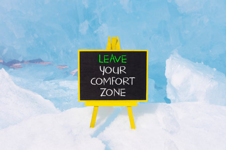 Leave your comfort zone symbol. Concept words Leave your comfort zone on beautiful black blackboard. Beautiful blue ice background. Business psychological Leave your comfort zone concept. Copy space.の写真素材