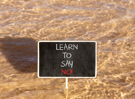 Learn to say no symbol. Concept words phrase Learn to say no on beautiful black blackboard. Beautiful Red sea water background. Business psychological Learn to say no concept. Copy space.の写真素材