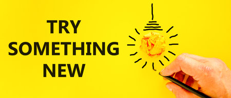 Try something new symbol. Concept words Try something new on beautiful paper. Beautiful yellow background. Businessman hand, pen. Business motivational lifestyle try something new concept. Copy space.の写真素材