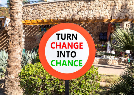 Turn change into chance symbol. Concept words phrase Turn change into chance on beautiful road sign. Beautiful palm tree background. Business Turn change into chance concept. Copy space.の写真素材