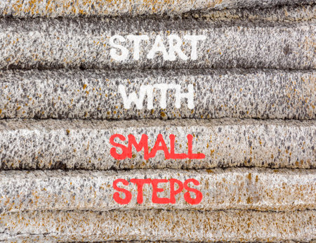 Start with small steps symbol. Concept words phrase Start with small steps on beautiful gray stone wall. Beautiful stone wall background. Business Start with small steps concept. Copy space.の写真素材