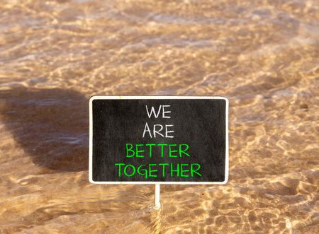 We are better together symbol. Concept words phrase We are better together on beautiful black blackboard. Beautiful Red sea water background. Business We are better together concept. Copy space.の写真素材