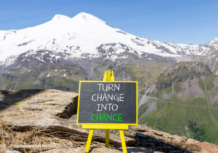 Turn change into chance symbol. Concept words phrase Turn change into chance on beautiful black blackboard. Beautiful mountain Elbrus background. Business Turn change into chance concept. Copy space.の写真素材