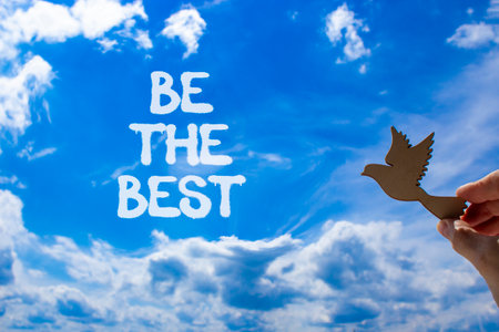 Motivational be the best symbol. Concept words Be the best on beautiful blue sky. Beautiful blue sky and clouds background. Businessman hand. Business motivational be the best concept. Copy space.の写真素材