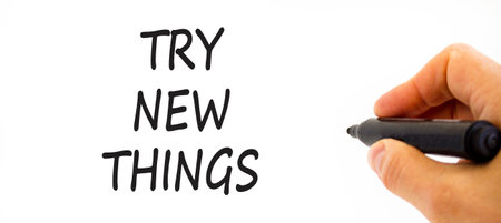 Try new things symbol. Concept words Try new things on beautiful white paper. Beautiful white background. Businessman hand, pen. Business motivational lifestyle try new things concept. Copy space.の写真素材