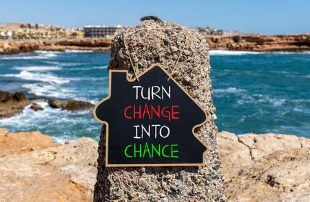 Turn change into chance symbol. Concept words phrase Turn change into chance on beautiful black blackboard. Beautiful stone blue sea background. Business Turn change into chance concept. Copy space.の写真素材