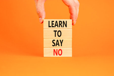 Learn to say no symbol. Concept words phrase Learn to say no on beautiful wooden blocks. Beautiful orange paper background. Businessman's hand Business psychological Learn to say no concept Copy spaceの写真素材
