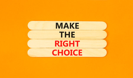 Make the right choice symbol. Concept words phrase Make the right choice on beautiful wooden stick. Beautiful orange paper background. Business Make the right choice concept. Copy space.の写真素材