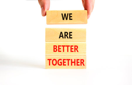 We are better together symbol. Concept words phrase We are better together on beautiful wooden blocks. Beautiful white background. Businessman hand. Business We are better together concept. Copy spaceの写真素材