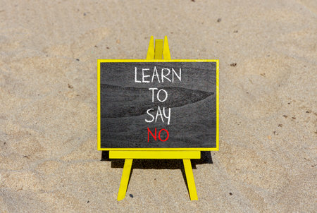 Learn to say no symbol. Concept words phrase Learn to say no on beautiful black blackboard. Beautiful sand beach background. Business psychological Learn to say no concept. Copy space.の写真素材