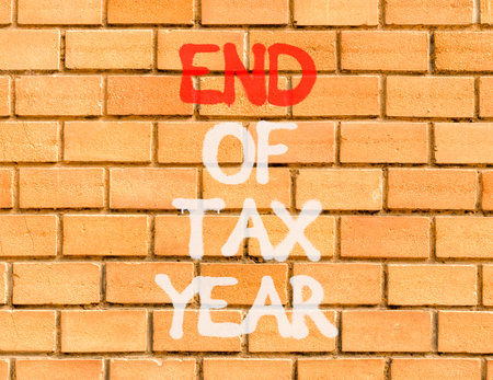 End of tax year symbol. Concept words phrase End of tax year on beautiful brown brick wall. Beautiful brown brick wall background. Business End of tax year concept. Copy space.の写真素材
