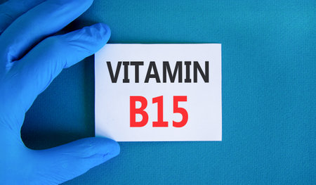 Vitamin B15 pantothenic acid symbol. Concept words Vitamin B15 on beautiful white card. Doctor's hand in blue medical glove. Beautiful blue background. Medical healthy lifestyle Vitamin B15 concept.の写真素材