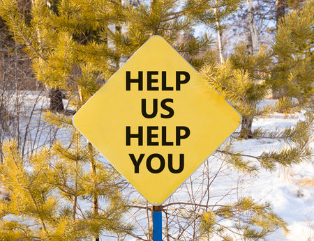 Help you symbol. Concept words phrase Help us help you on beautiful yellow road sign. Beautiful winter forest background. Business Help you concept. Copy space.の写真素材