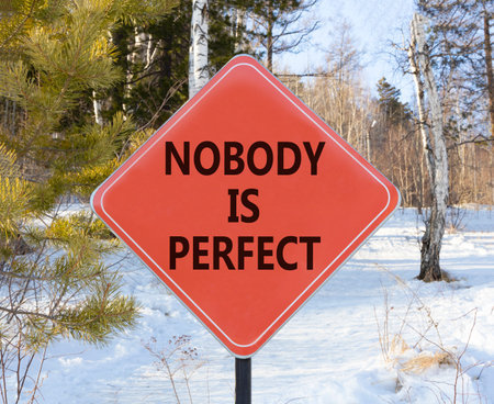 Nobody is perfect symbol. Concept words Nobody is perfect on beautiful red road sign. Beautiful winter forest background. Business motivational lifestyle and nobody is perfect concept. Copy space.の写真素材
