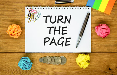 Turn the page symbol. Concept words Turn the page on beautiful white note. Black pen. Colored paper. Beautiful wooden background. Business motivational lifestyle turn the page concept. Copy space.の写真素材
