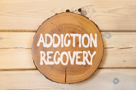 Addiction recovery symbol. Concept words Addiction recovery on beautiful wooden circle. Beautiful wooden wall background. Psychology addiction recovery concept. Copy space.の写真素材