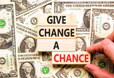Give change a chance symbol. Concept words phrase Give change a chance on beautiful wooden blocks. Dollar bills. Beautiful dollar bills background. Business Give change a chance concept. Copy space.の写真素材