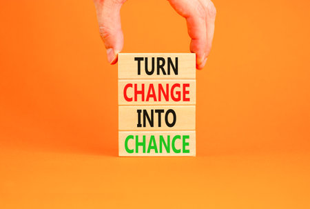 Turn change into chance symbol. Concept words phrase Turn change into chance on beautiful wooden blocks. Beautiful orange paper background. Business Turn change into chance concept. Copy space.の写真素材