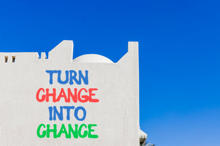 Turn change into chance symbol. Concept words phrase Turn change into chance on beautiful white wall. Beautiful white wall and blue sky background. Business Turn change into chance concept. Copy spaceの写真素材