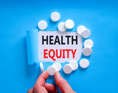 Health equity symbol. Concept words Health equity on beautiful white paper. White pills tablets. Doctor's hand. Beautiful blue background. Medical healthy lifestyle health equity concept.の写真素材