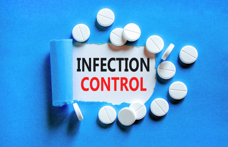 Infection control symbol. Concept words Infection control on beautiful white paper. White pills tablets. Beautiful blue background. Medical healthy lifestyle infection control concept.の写真素材