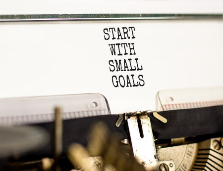 Start with small goals symbol. Concept words phrase Start with small goals typed on beautiful retro old typewriter. Beautiful white background. Business Start with small goals concept. Copy space.の写真素材