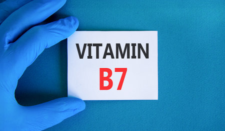 Vitamin B7 biotin symbol. Concept words Vitamin B7 on beautiful white card. Doctor's hand in blue medical glove. Beautiful blue background. Medical healthy lifestyle Vitamin B7 concept.の写真素材