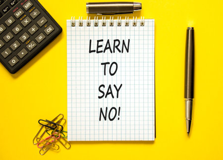 Learn to say no symbol. Concept words phrase Learn to say no on beautiful white note. Black pen. Calculator. Beautiful yellow background. Business psychological Learn to say no concept. Copy space.の写真素材