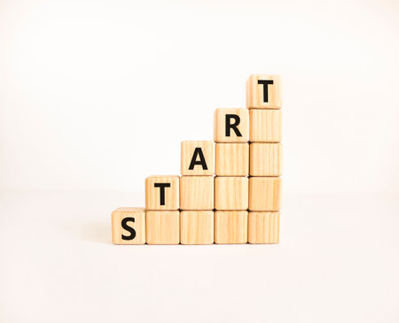 Start symbol. Concept word Start on beautiful wooden blocks. Beautiful white table white background....